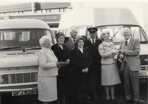 Group standing in front of 2 minibuses