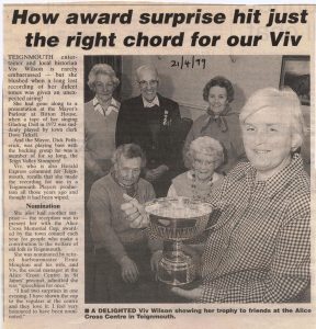 Newspaper article photo of Viv Wilson receiving the trophy with supporters behind